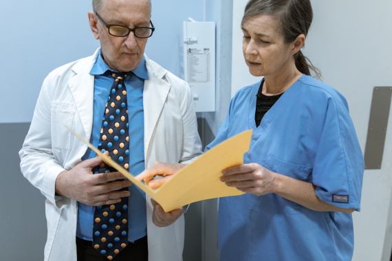 A doctor and nurse reviewing a patients notes after a power of attorney made a decision