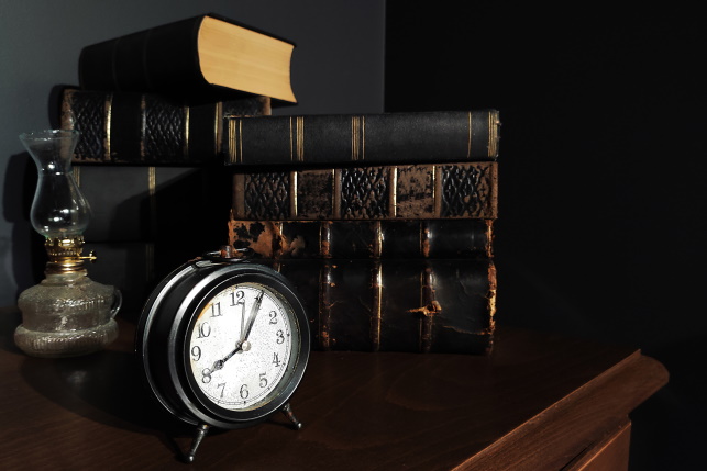 An old clock and books on a cabinet